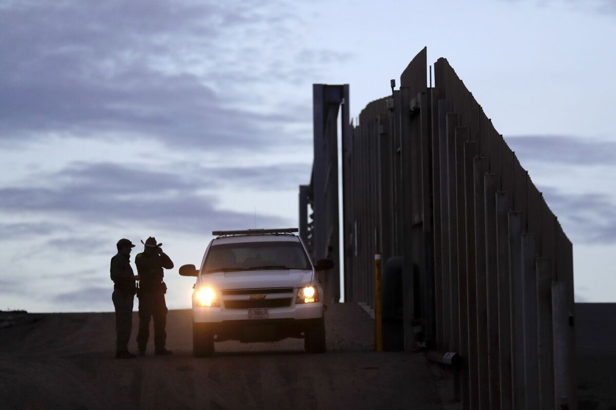 FILE - In this Nov. 21, 2018 file photo, United States Border Patrol agents stand by a vehicle near one of the border walls separating Tijuana, Mexico and San Diego, in San Diego. As of this week, the ACLU has filed nearly 400 lawsuits and other legal actions against the Trump administration, some meeting with setbacks but many resulting in important victories. Of the lawsuits, 174 have dealt with immigrant rights, targeting the family separation policy, detention and deportation practices, and the administration’s repeated attempts to make it harder to seek asylum at the U.S.-Mexico border. (AP Photo/Gregory Bull, File)