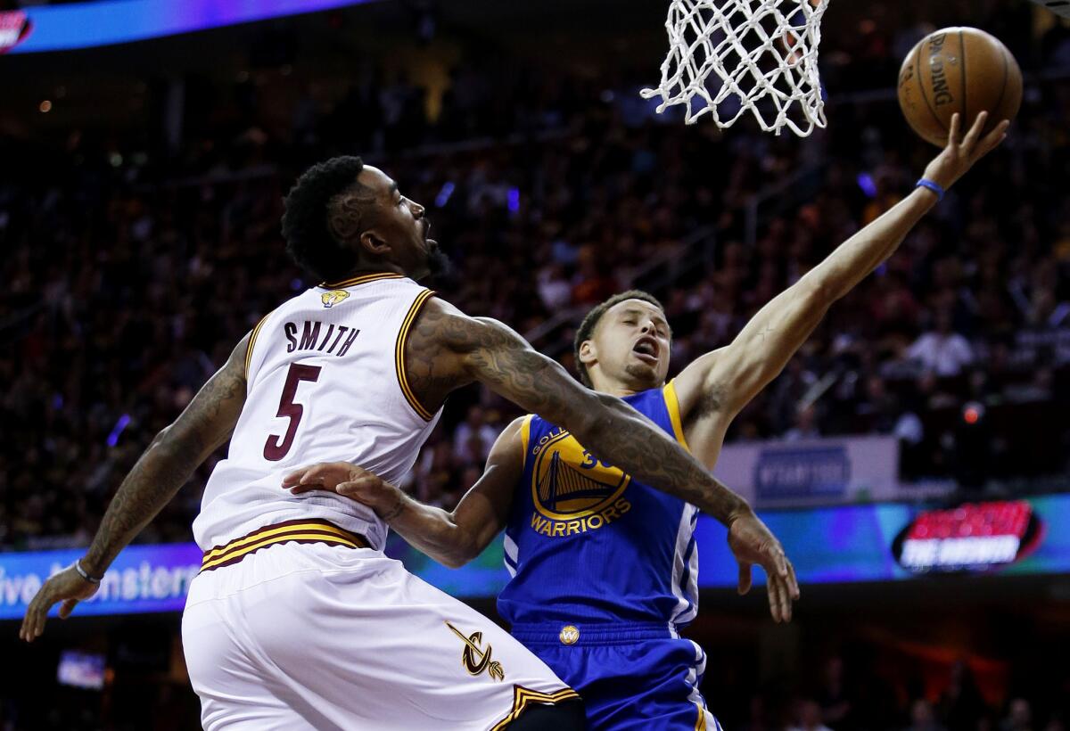 Warriors point guard Stephen Curry drives for a layup against Cavaliers guard J.R. Smith in the first half of Game 6.