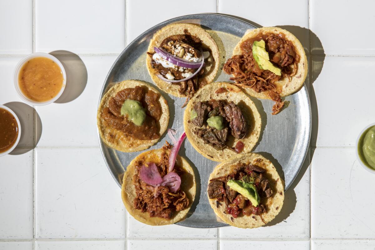 A taco sampler and sides of salsas at the original Guisados in Boyle Heights