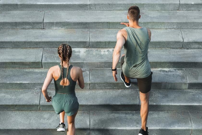 Young couple runs the stairs during an outdoor workout.