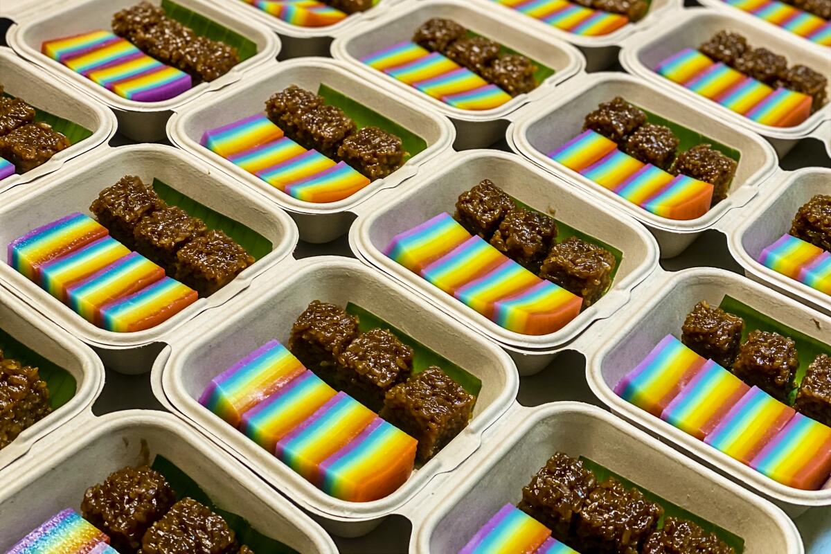 White boxes that each hold rainbow bar desserts and brown bar desserts.
