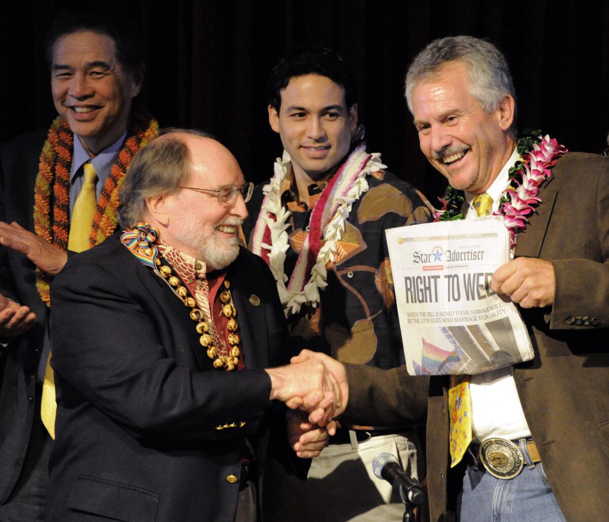 Gov. Neil Abercrombie, left, and former Sen. Avery Chumley hold a copy of the Star Advertiser after Abercrombie signed the bill legalizing gay marriage in Hawaii on Nov. 13, becoming the 15th state to legalize same-sex marriage.