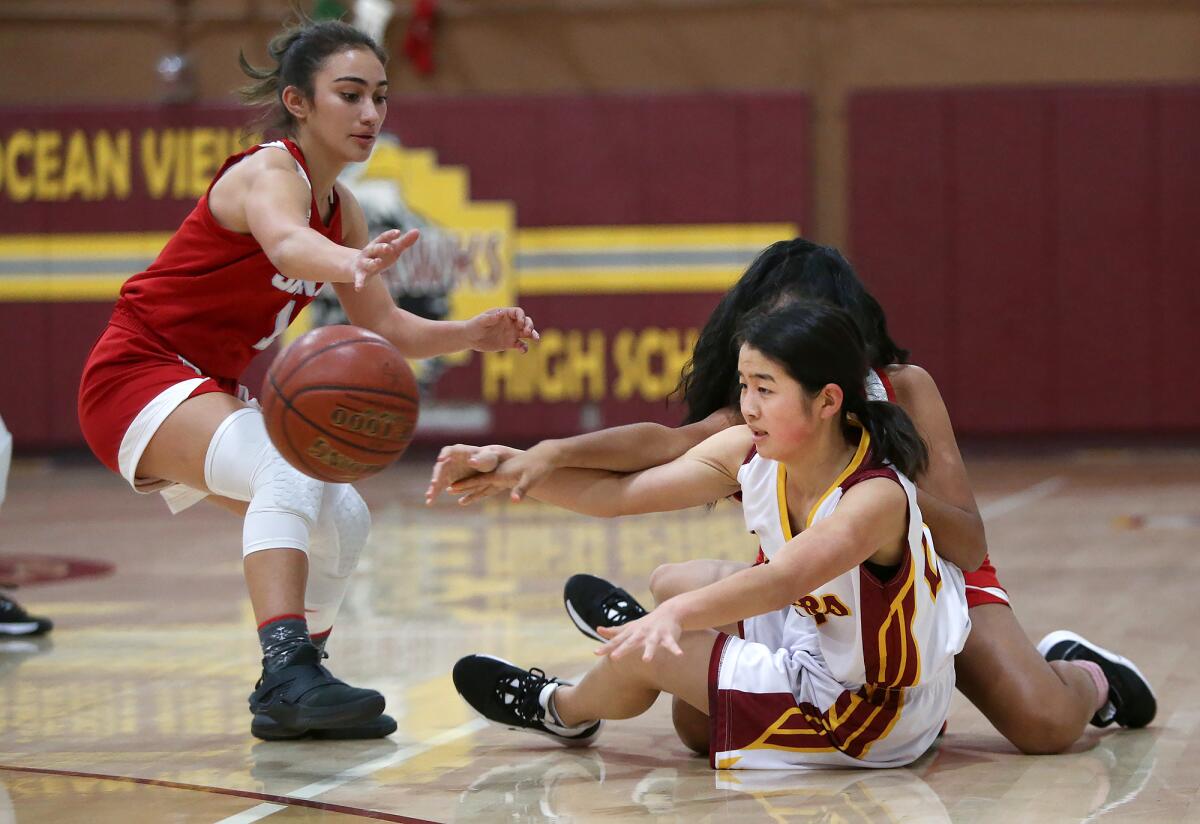 Ocean View's Haley Bae gets a pass off after battling for a loose ball with Santa Ana's Melina Rueda, behind, and Julianna Robles in a Hawk Holiday Classic game on Tuesday.