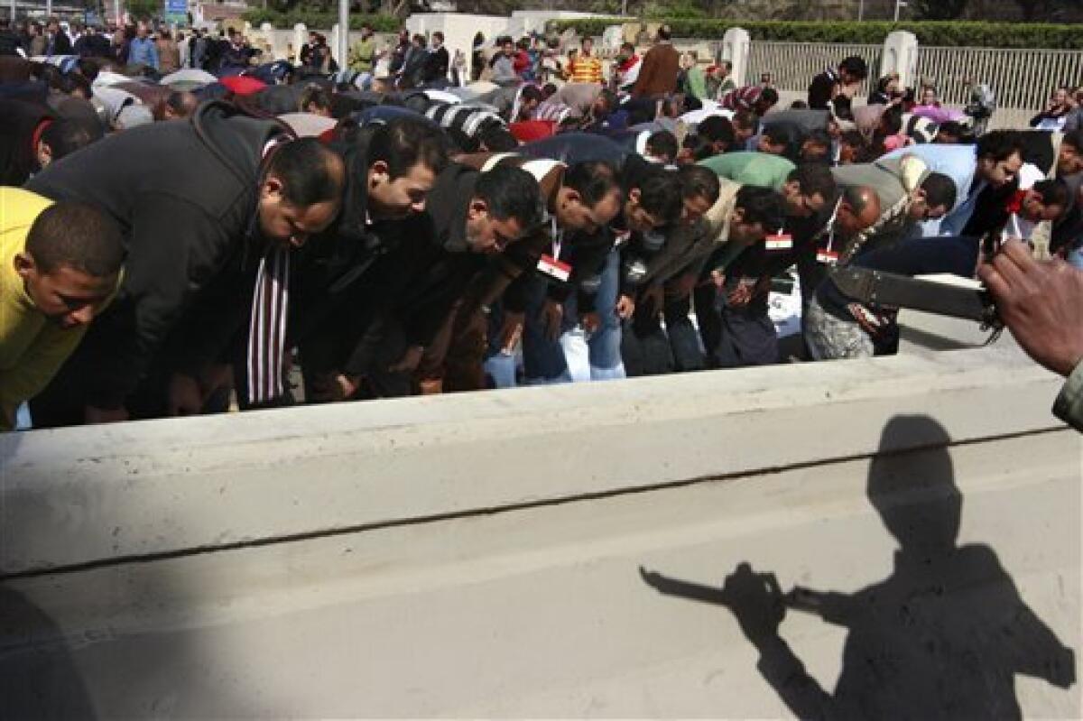 A shadow of an Egyptian army soldier is seen as pro-Mubarak supporters perform prayers during a march in Cairo, Egypt, Tuesday, Feb. 1, 2011. Egyptian authorities battled to save President Hosni Mubarak's regime with a series of concessions and promises to protesters, but realities on the streets of Cairo may be outrunning his capacity for change. (AP Photo/Amr Nabil)