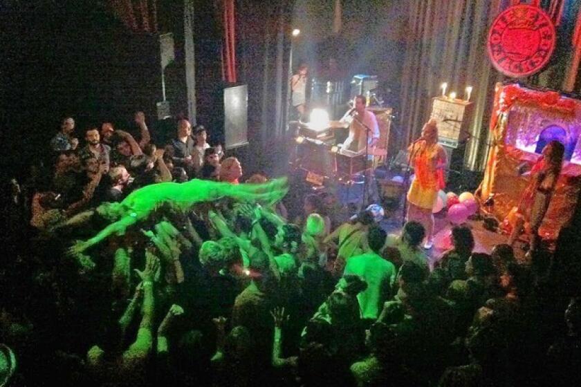 A fan crowd surfs during a riotous set by rocker Quintron at One Eyed Jacks in New Orleans.