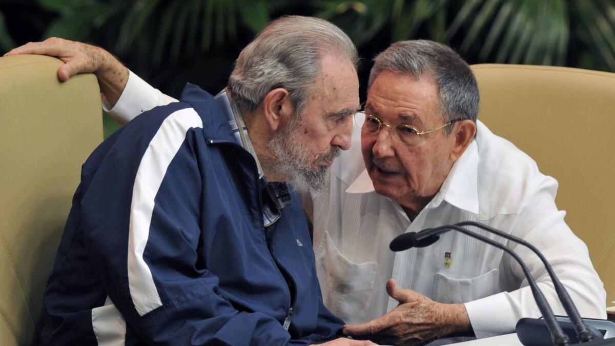 The late Fidel Castro, left, listens to his brother Raul, Cuba's president, at the Convention Palace in Havana in 2011.