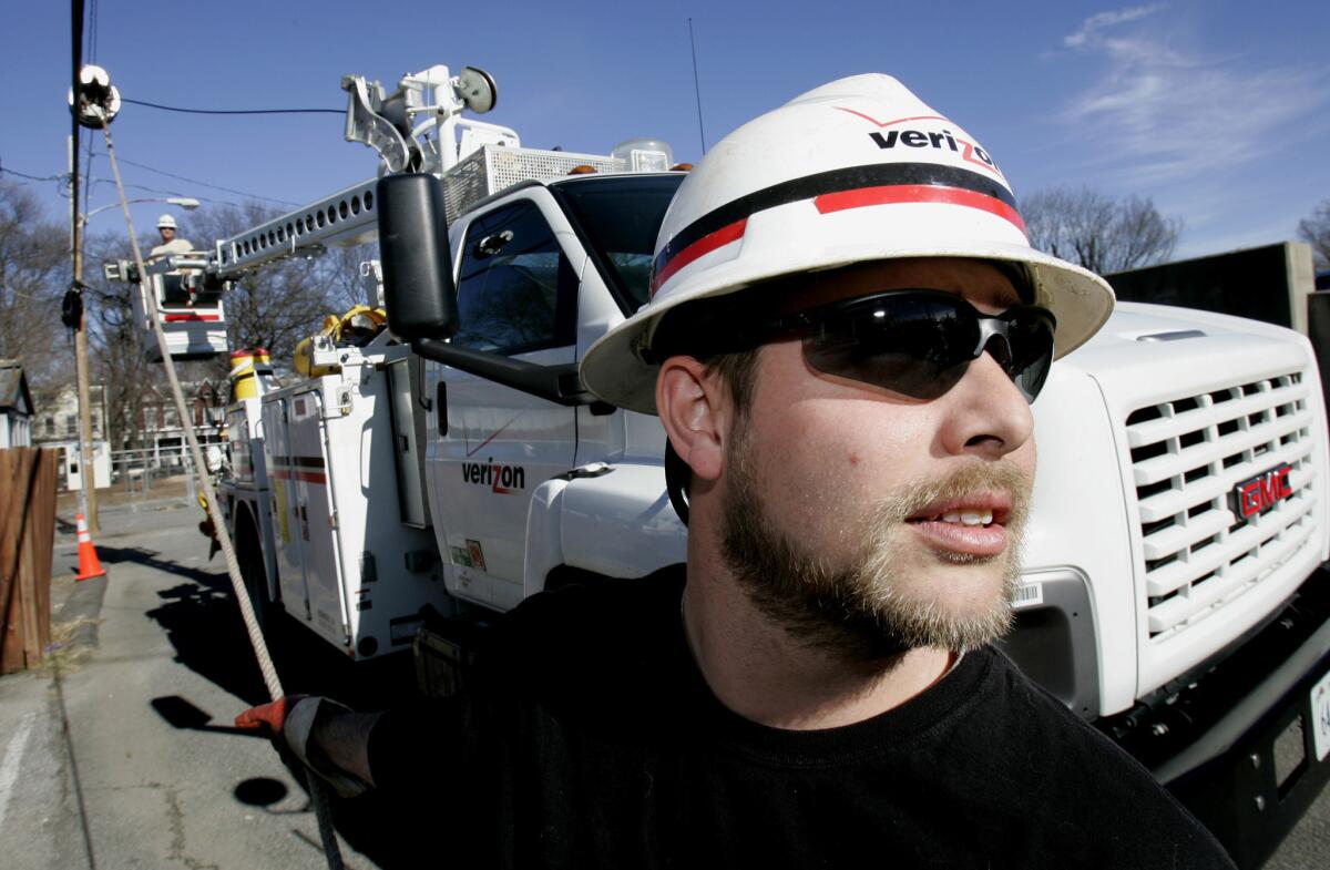 Verizon Utility worker Brian Roop pulls a cable as he and co-worker Steve Hammond install fiber-optic cable in Virginia.