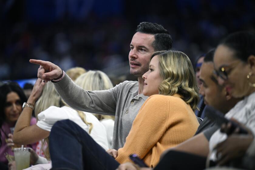 Former Orlando Magic guard JJ Redick, center, and his wife, Chelsea Kilgore, third from right, watch from court side seats during the second half of an NBA basketball game against the New York Knicks, Wednesday, Feb. 14, 2024, in Orlando, Fla. (AP Photo/Phelan M. Ebenhack)