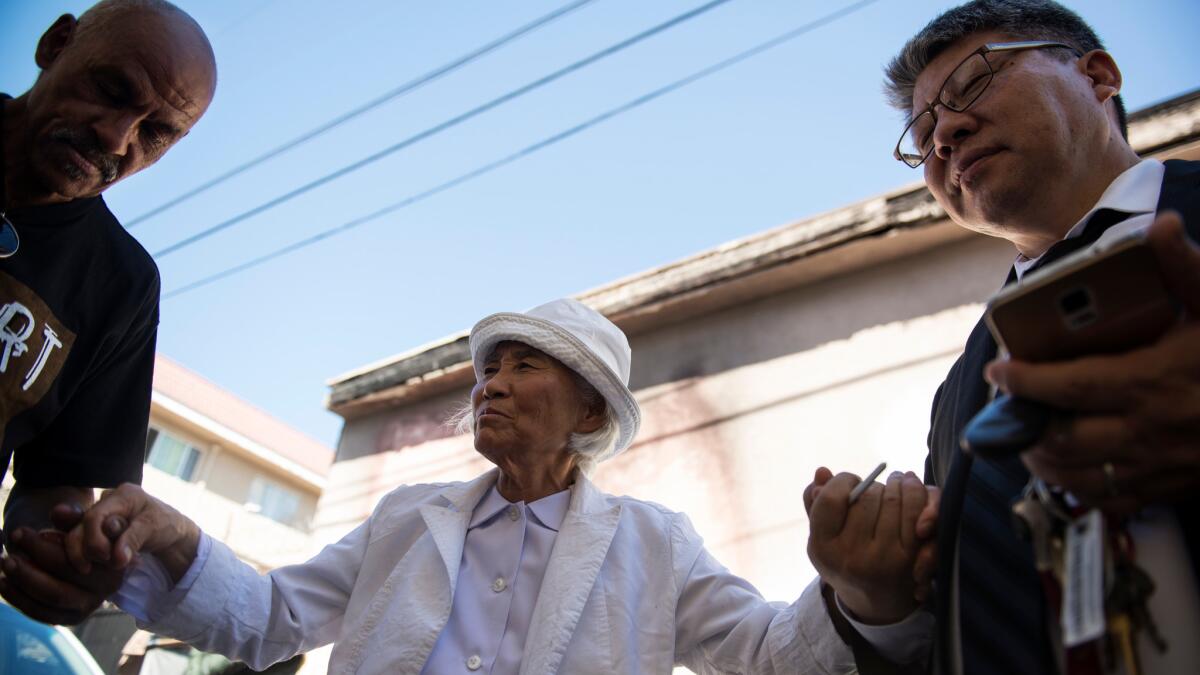 Gloria Kim, who operates a traveling soup kitchen, prays in the alley that Prince called home in Los Angeles.