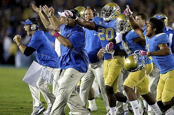 UCLA players and coaches react as the Bruins defense makes a key stop against California in the fourth quarter Saturday night at the Rose Bowl in a 31-14 victory.