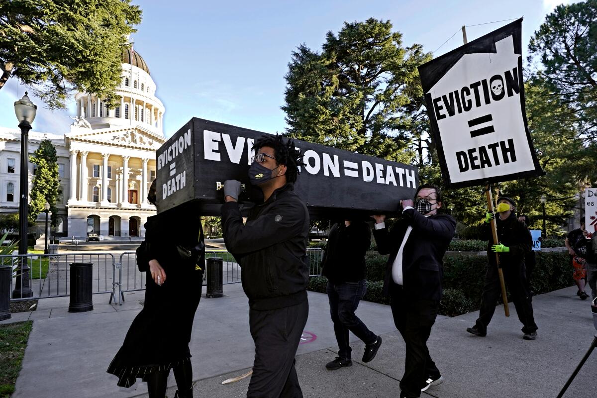 Demonstrators carry a mock casket that says "eviction = death" past the Capitol in Sacramento.