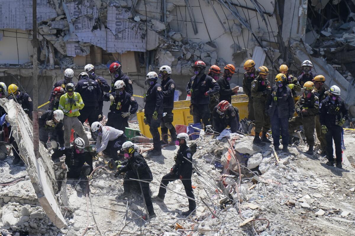Search and rescue personnel atop the rubble