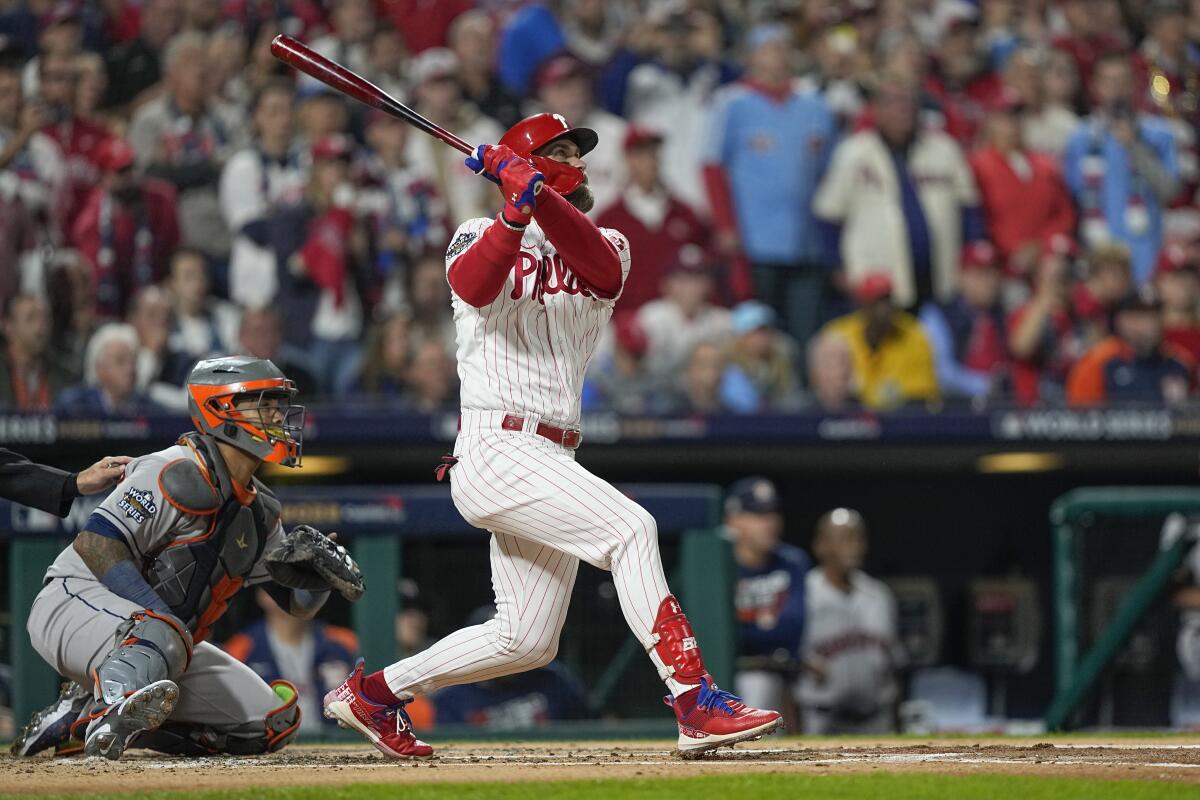 Philadelphia Phillies' Bryce Harper watches his two-run home run during the first inning in Game 3 of the World Series.