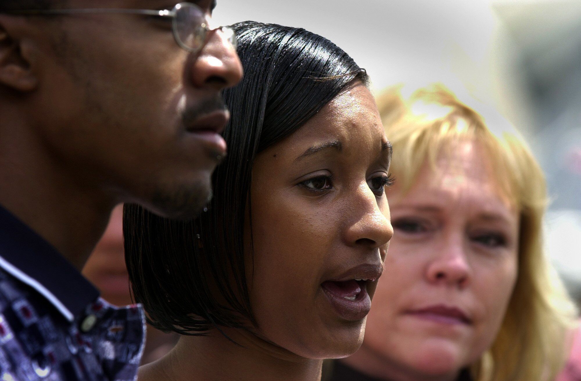 Tameka Jones, with Tieray Jones and Brenda van Dam, speaks at a news conference.