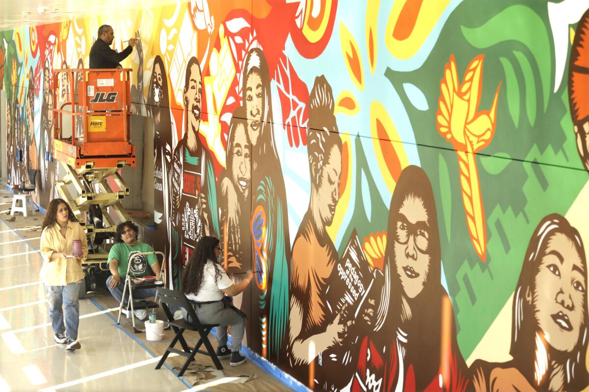Four people work on a mural