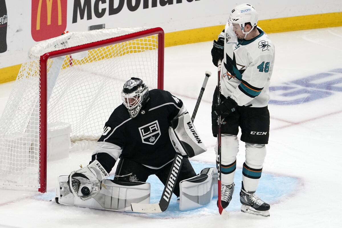 Kings goalie Cal Petersen stops a shot with the Sharks' Tomas Hertl nearby in the second period April 2, 2021.