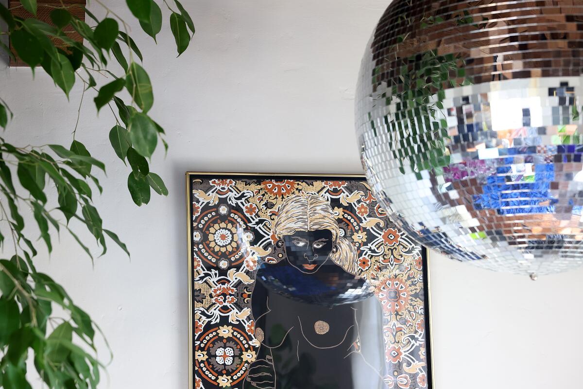 A mirror ball hanging from the roof in front of a paint