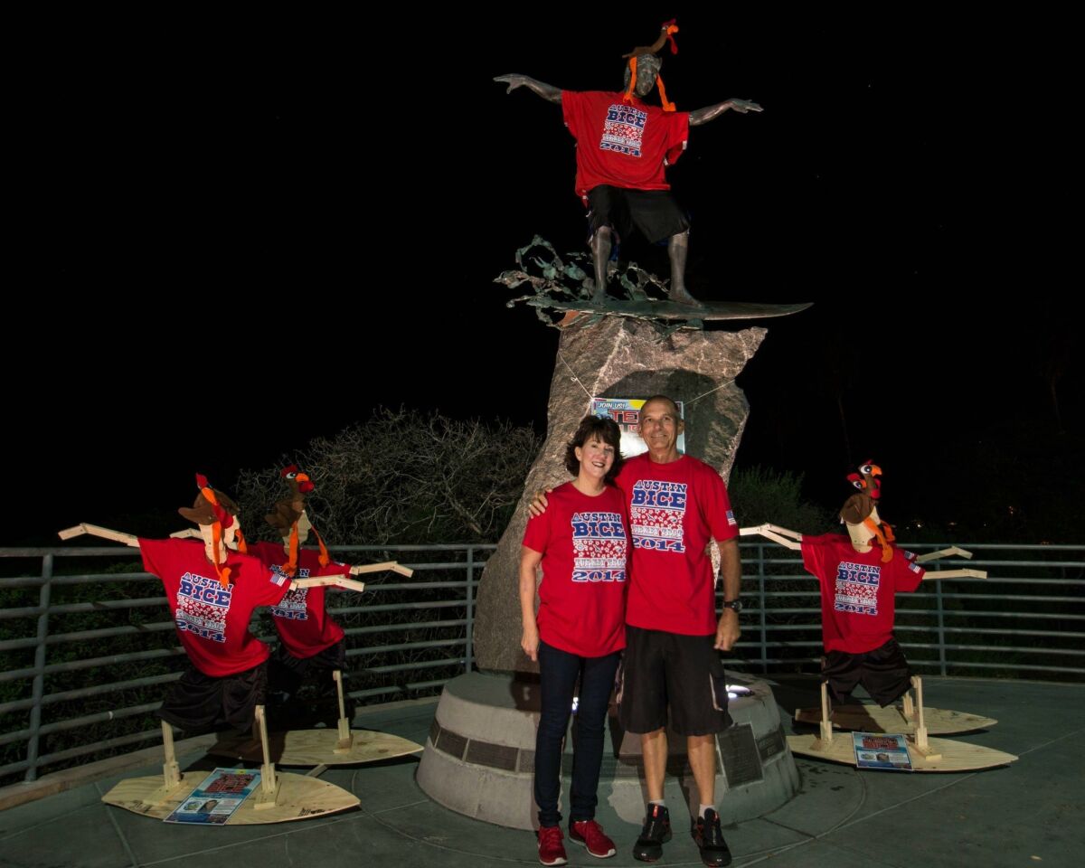 Larry and Pam Bice pose in front of the Cardiff Kook statue, which Team Austin Bice decorated in November 2014 for the annual Oceanside Turkey Trot. The team runs to raise money for a scholarship established in the name of the couple's 22-year-old son, who died while studying abroad in Spain in 2011. Connie Hatfield