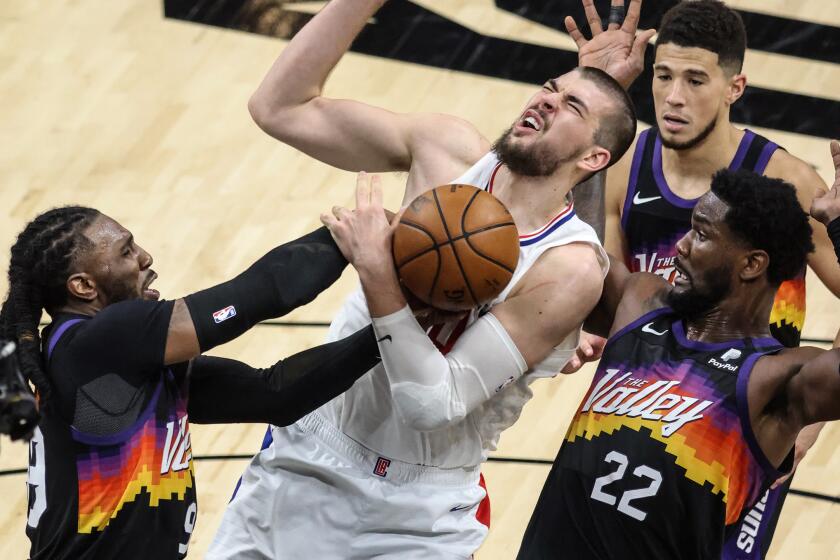 Clippers center Ivica Zubac tries to score inside against Phoenix's Jae Crowder, left, and Deandre Ayton in Game 2.