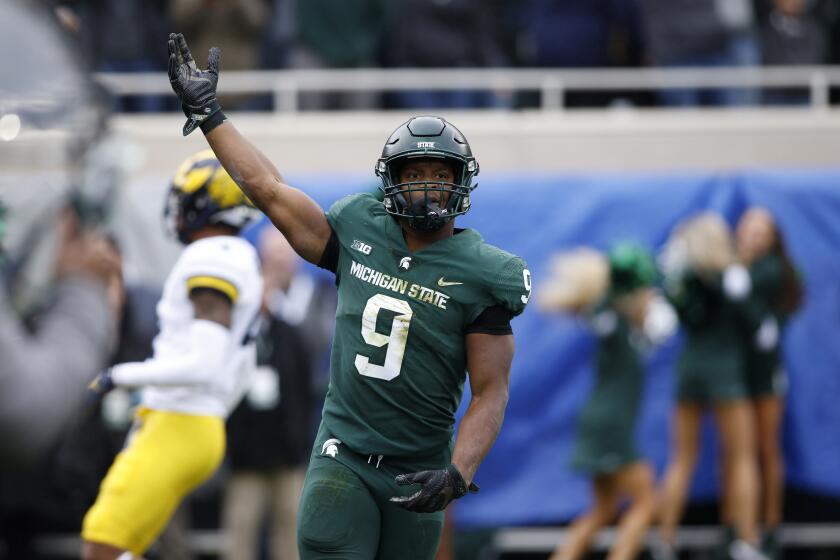 Michigan State's Kenneth Walker III celebrates his touchdown against Michigan during an NCAA college football game, Saturday, Oct. 30, 2021, in East Lansing, Mich. Michigan State won 37-33. (AP Photo/Al Goldis)