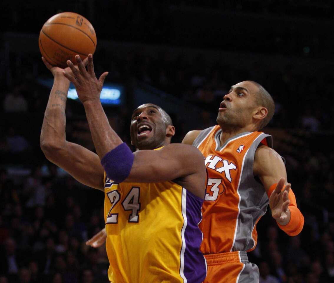 Lakers guard Kobe Bryant beats Suns forward Grant Hill inside for a layup in the first half Friday night at Staples Center.