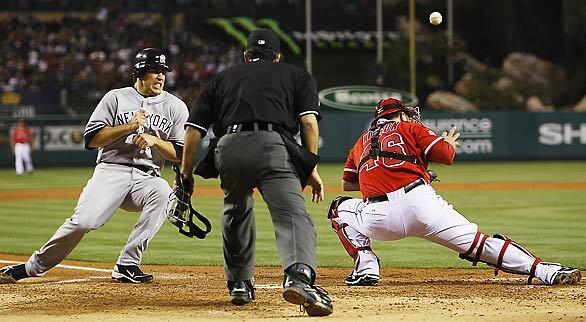 Yankees baserunner Mark Teixeira prepares for a collision with Angels catcher Bobby Wilson, who can't make the catch on a throw to the plate by right fielder Bobby Abreu in the third inning Friday night.