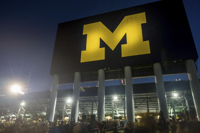 Fans walk outside Michigan Stadium under the north scoreboard before Michigan's game against Wisconsin on Oct. 13, 2018.