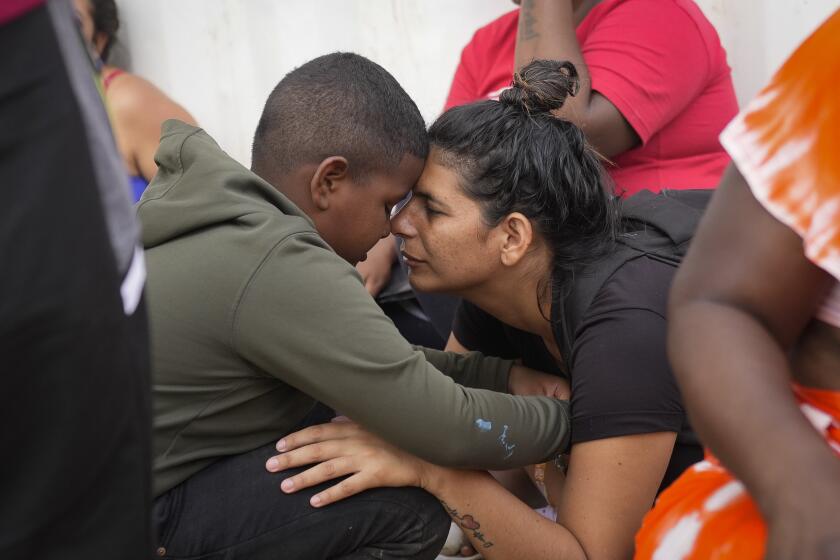 La migrante venezolana Nelsy Zavala, a la derecha, abraza a un chico migrante venezolano Yeikel Mojica, a quien conoció mientras cruzaba el Tapón del Darién y dice que era como un hermano pequeño para ella, en un campamento temporal en Lajas Blancas, Panamá, el jueves 27 de junio de 2024. ( Foto AP/Matías Delacroix)