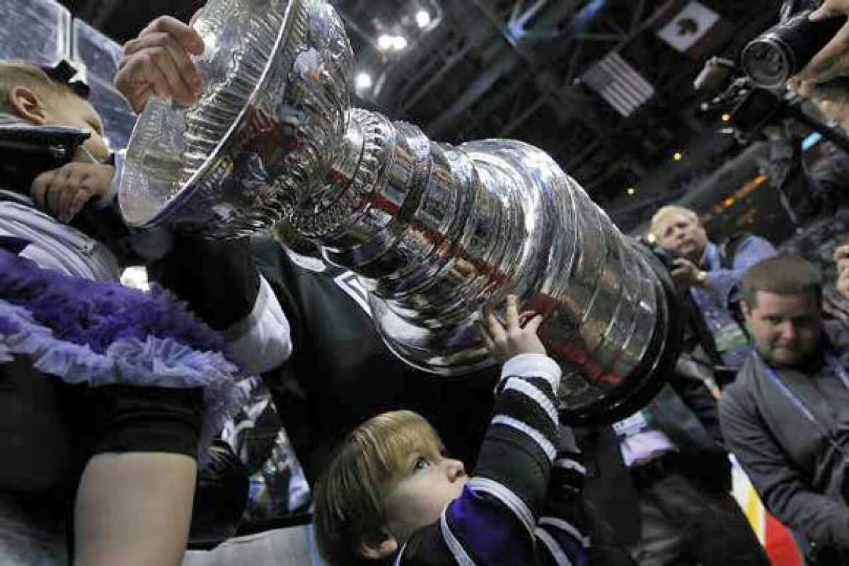Family members of Kings player Mike Richards hold the Stanley Cup after Monday's victory.