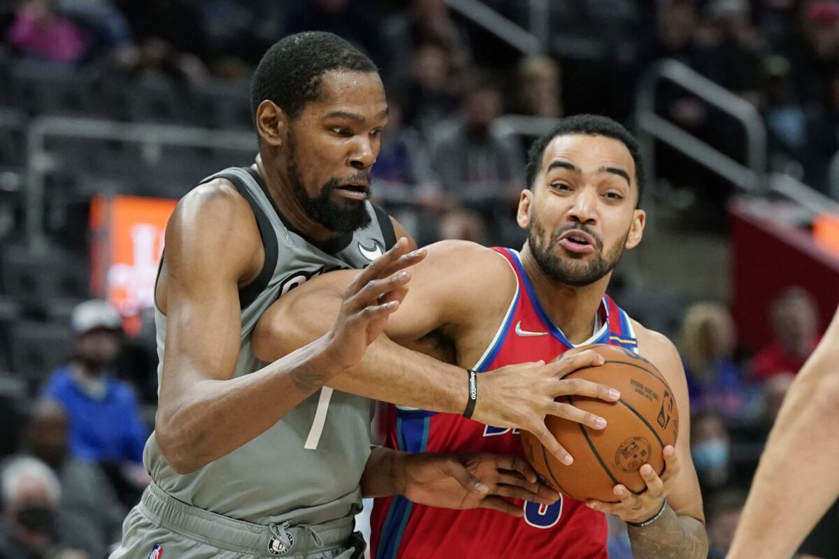 Detroit Pistons forward Trey Lyles (8) is defended by Brooklyn Nets forward Kevin Durant (7) during the first half of an NBA basketball game, Sunday, Dec. 12, 2021, in Detroit. (AP Photo/Carlos Osorio)