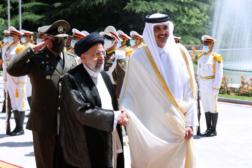 In this photo released by the official website of the office of the Iranian Presidency, Qatari Emir Sheikh Tamim bin Hamad Al Thani, right, shakes hands with President Ebrahim Raisi during an official arrival ceremony at the Saadabad Palace in Tehran, Iran, Thursday, May 12, 2022. Qatar's emir arrived in Tehran for talks with the Iranian president as efforts to save Tehran's tattered nuclear deal with world powers hit a deadlock. (Iranian Presidency Office via AP)