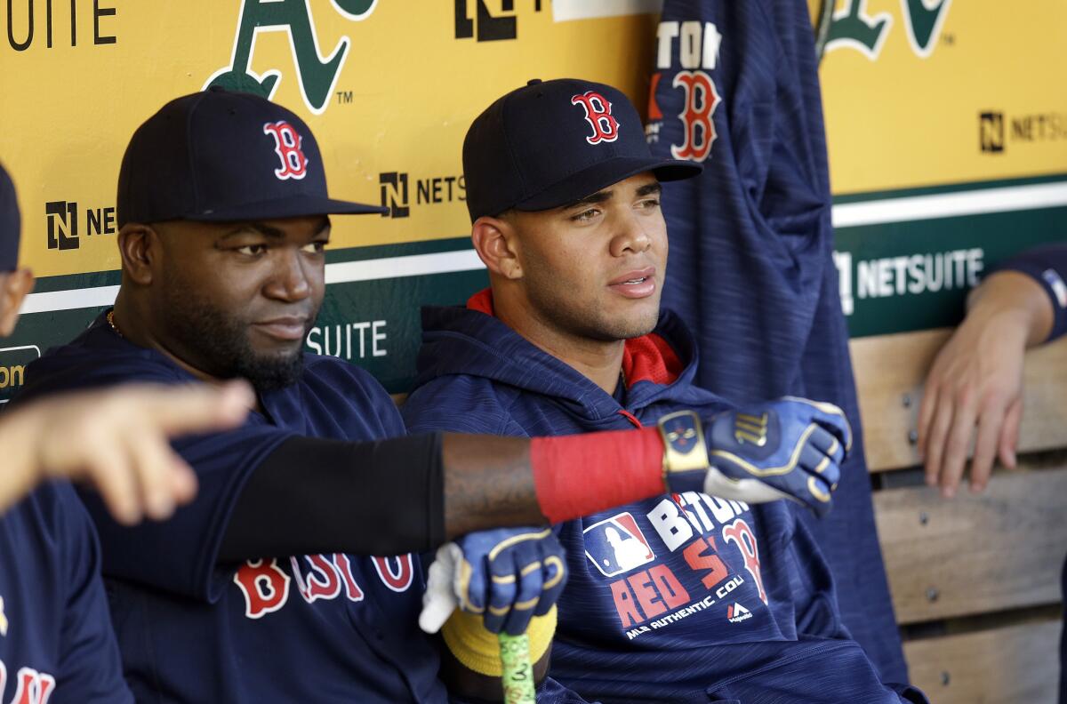 Yoan Moncada, right, sits beside David Ortiz in the Boston Red Sox dugout on Sept. 2.