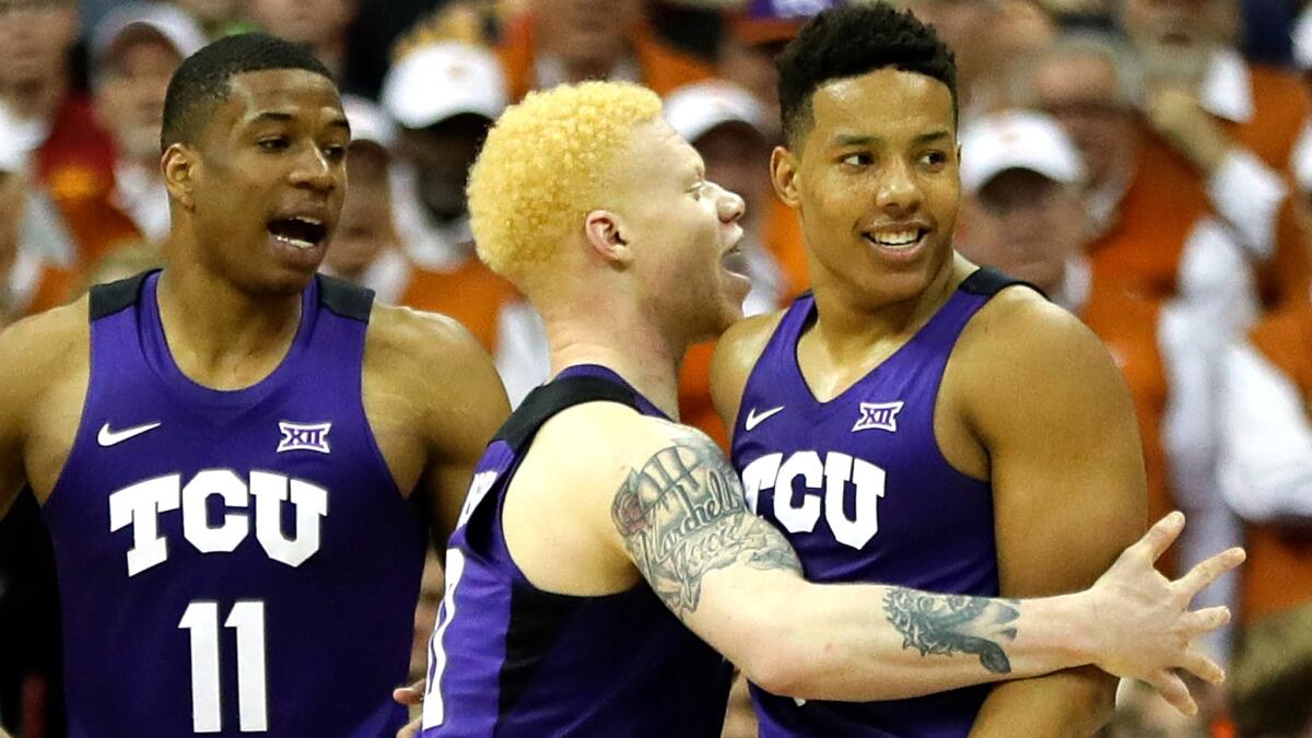 Kansas guard Desmond Bane, right, celebrates with teammates Jaylen Fisher, center and Brandon Parrish (11) in the closing seconds of their victory over Kansas on Thursday.