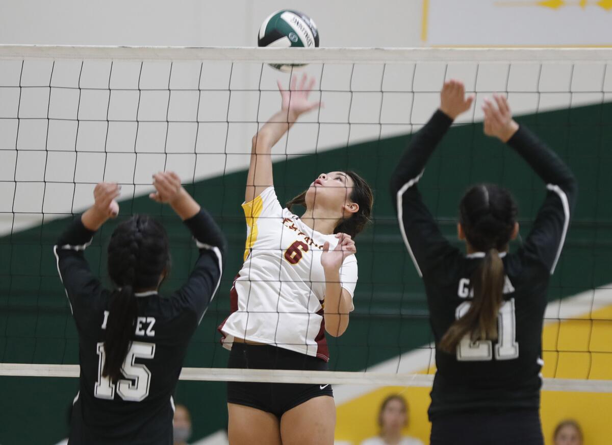 Estancia's Sydney Bilderback (6) kills the ball past two Rancho Alamitos blockers in a girls' volleyball match on Thursday.