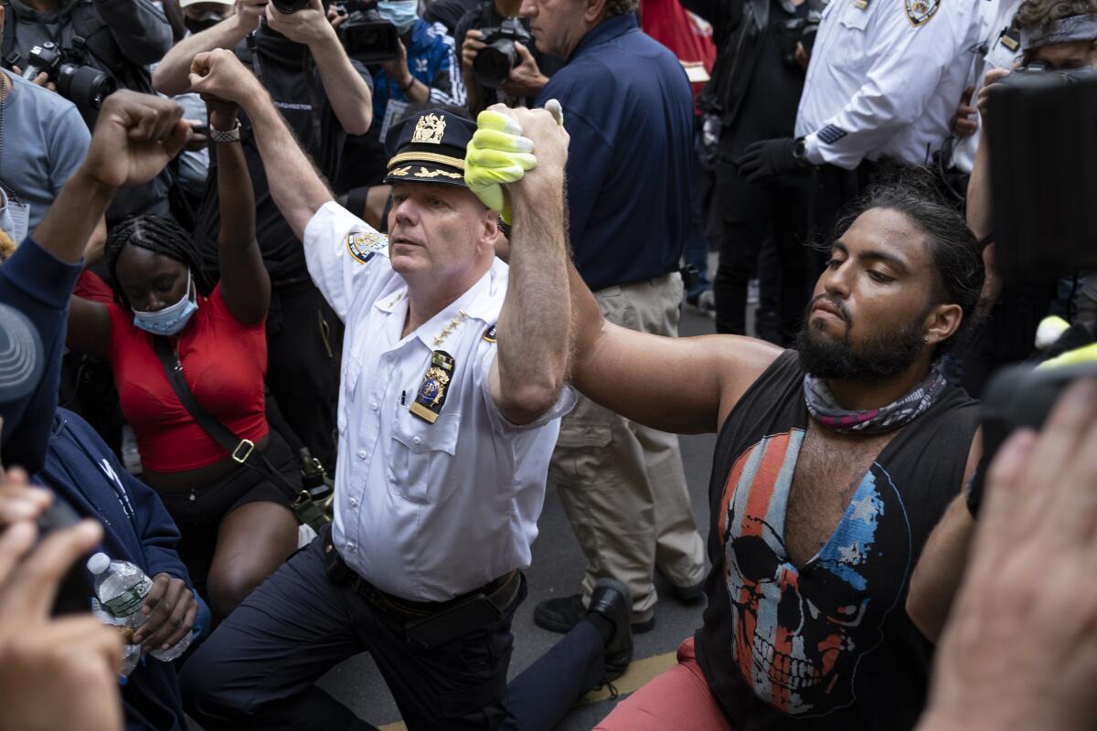 NYPD Chief of Department Terence Monahan kneels with protesters Monday in New York.