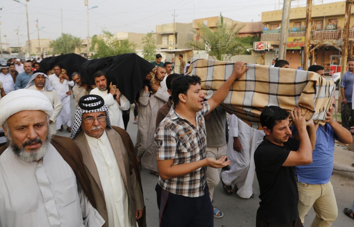 Mourners carry the coffins of relatives who were killed in a car bomb attack in the Shaoula neighbourhood of Baghdad October 12, 2014. At least 45 people were killed in bombings in Baghdad and its rural outskirts on Saturday as the government continued to defend the capital against jihadists who four months ago seized major cities in northern Iraq.