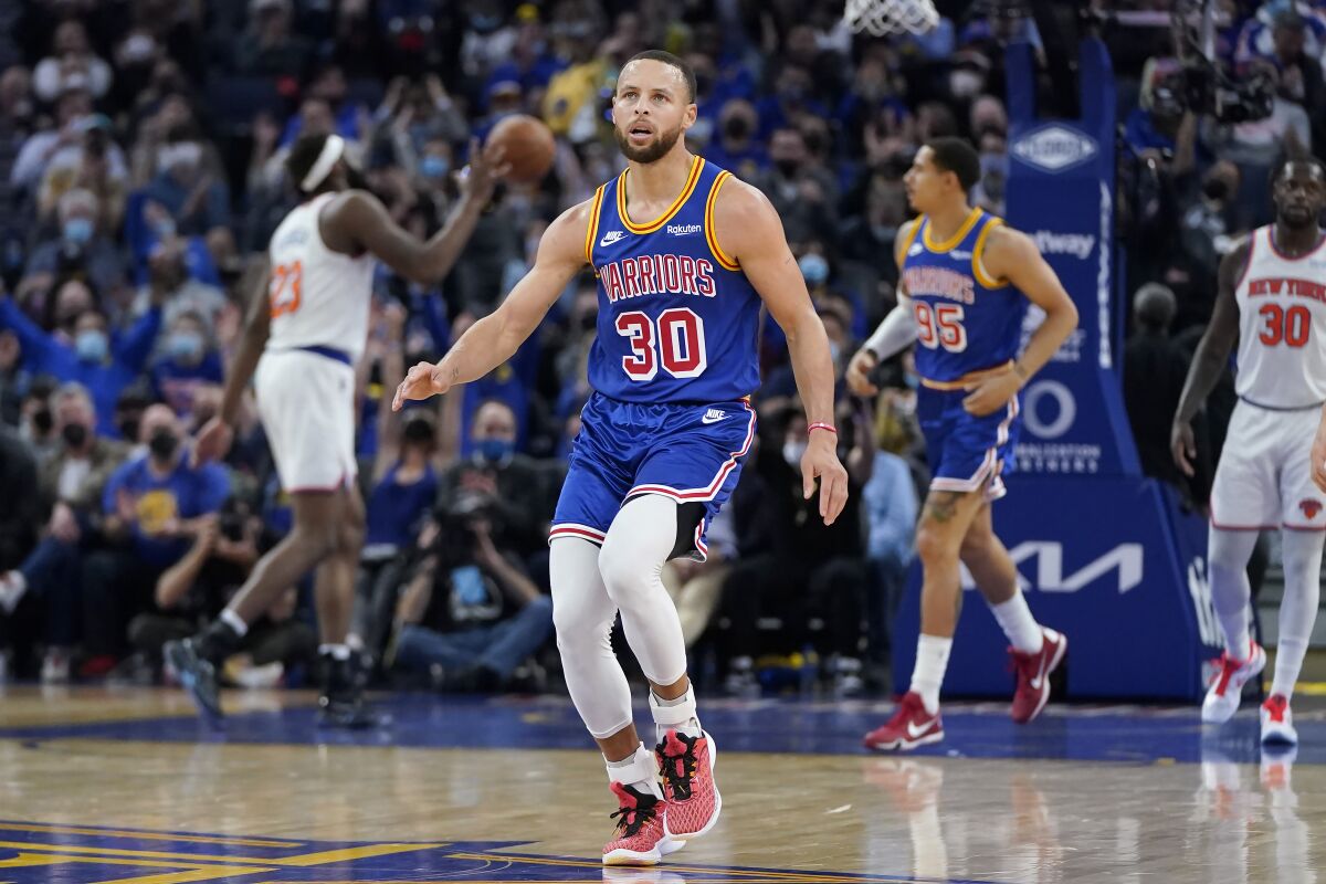 Golden State Warriors guard Stephen Curry (30) reacts after shooting a 3-point basket against the New York Knicks during the first half of an NBA basketball game in San Francisco, Thursday, Feb. 10, 2022. (AP Photo/Jeff Chiu)