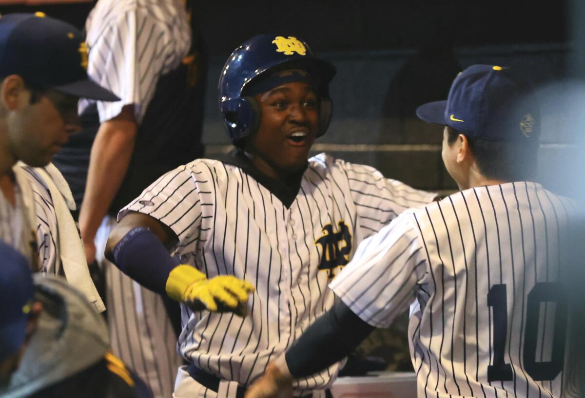 Dean West celebrates with his Sherman Oaks Notre Dame teammates in the dugout during an eight-run sixth-inning rally.