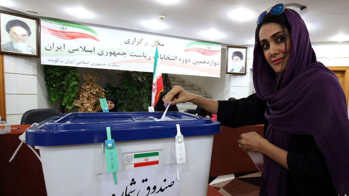 An Iranian woman, residing in Kuwait, casts her ballot for presidential and municipal elections on Friday at the Iranian embassy in Kuwait City.