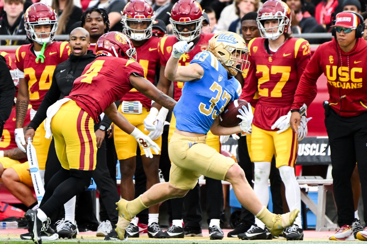 UCLA running back Carson Steele (33) runs the ball as USC safety Max Williams attempts to force Steele out of bounds 