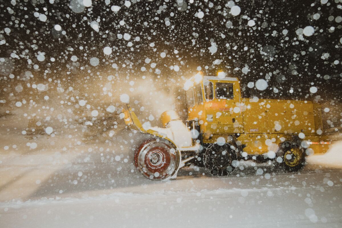 In this photo provided by the Mammoth Mountain Ski Area, a snowplow clears fresh snow at the Mammoth Mountain ski resort in Mammoth Lakes, Calif., on Monday, Dec. 13, 2021. Forecasters say the state's highest peaks could get as much as 8 feet of snow while lower elevations across California are in for a serious drenching of rain. The storm is expected to last days before moving out, but another storm is on the way. Forecasters warned people in mountainous areas to prepare for days of snowfall and possible road closures. (Peter Morning/Mammoth Mountain Ski Area via AP)