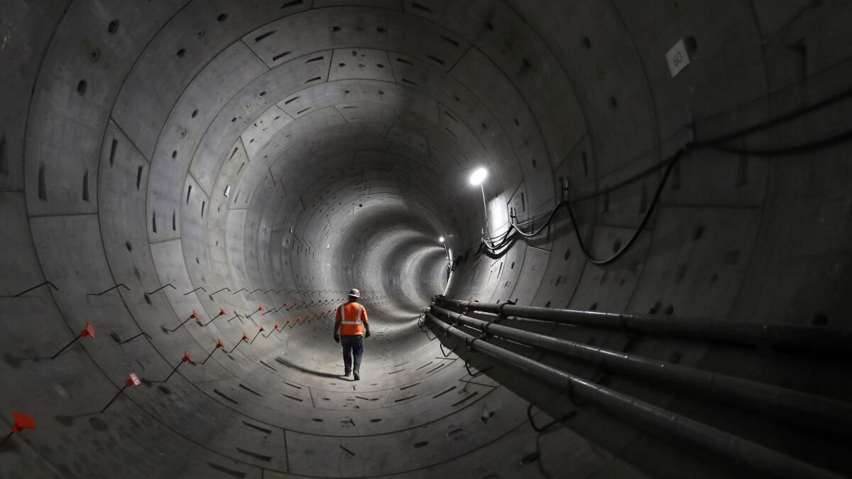Metro officials are considering routes for a light-rail line connecting downtown L.A. to cities in southeast L.A. County. Above, a worker in a tunnel under construction for Metro's Regional Connector project.