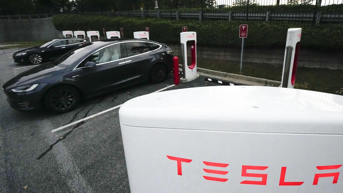 Tesla vehicles charge at a station