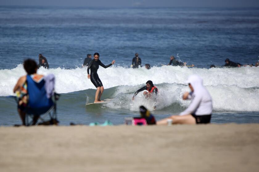 One day after Newport Beach opened up its beaches to recreational activities, dozens of surfers took to the water at the Newport Pier in Newport Beach on Thursday, May 7, 2020.
