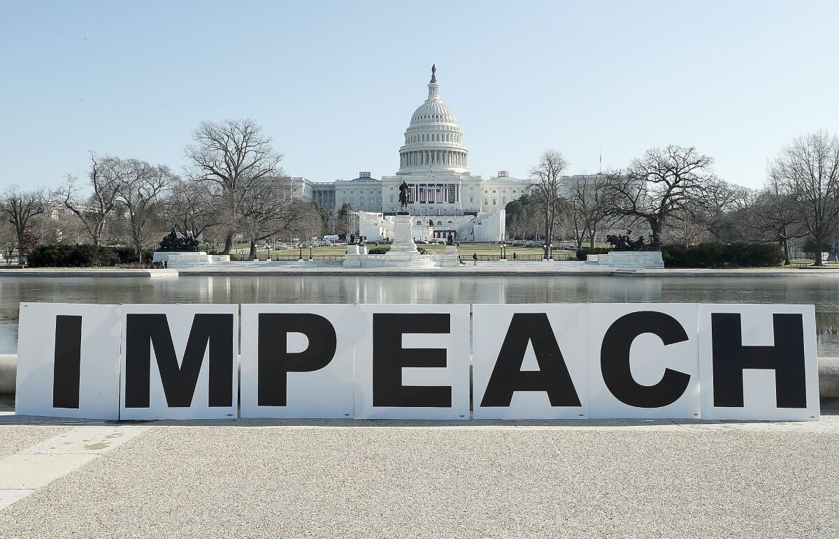 People gather at the base of the U.S. Capitol with large IMPEACH and REMOVE letters on January 12, 2021 in Washington, DC. 