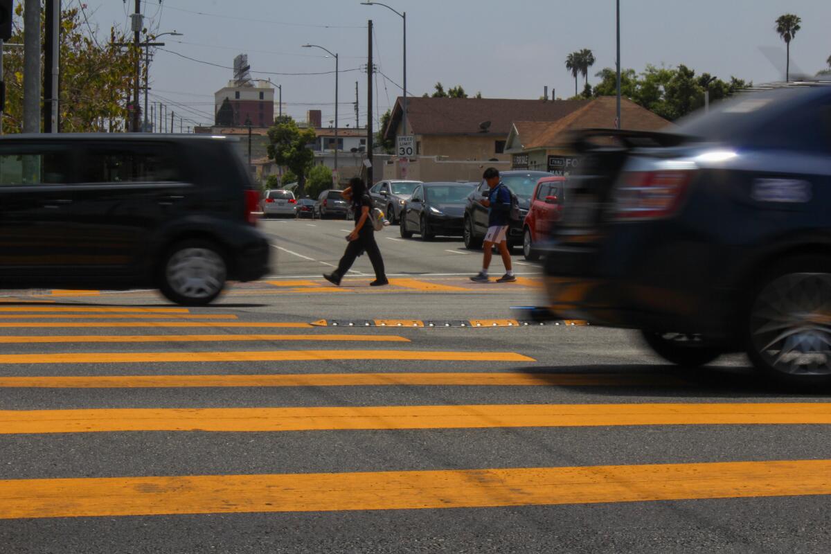 Children walk in a crosswalk at the busy intersection of Olympic Blvd. and Normandie Ave. in Koreatown.