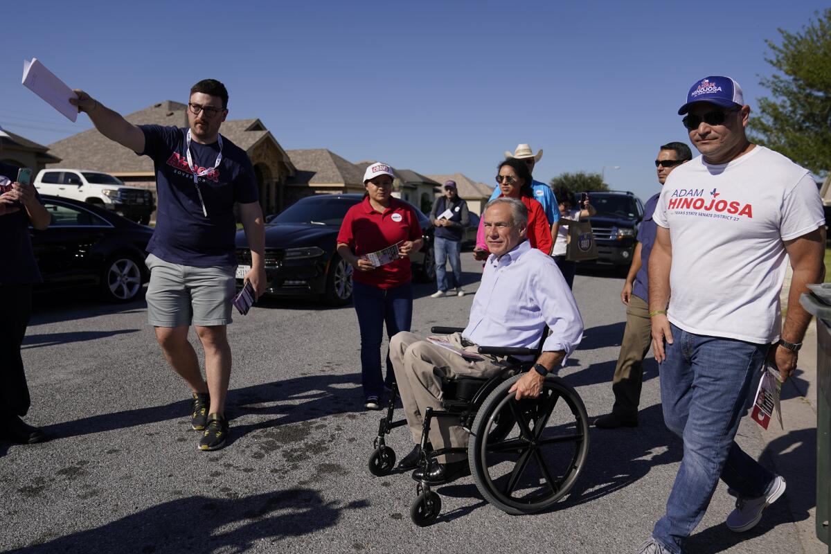 El gobernador de Texas Greg Abbott (en silla de ruedas) 