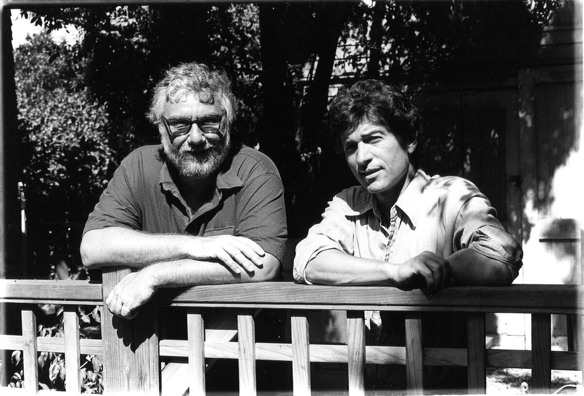 Gerald Locklin and Rafael "Ray" Zepeda pose while leaning on a railing.