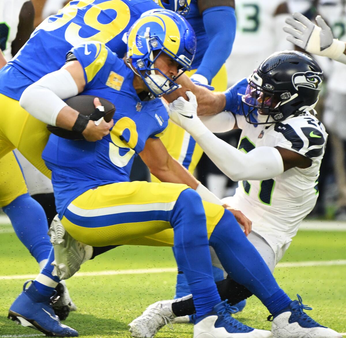 Rams' Matthew Stafford is tackled by Seattle Seahawks' Devon Witherspoon