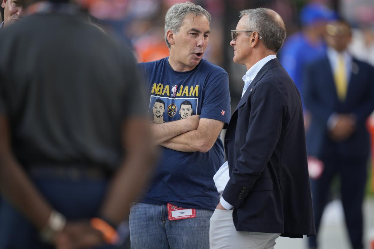 Rams COO Kevin Demoff chats with Denver Broncos president Greg Penner before a preseason game.